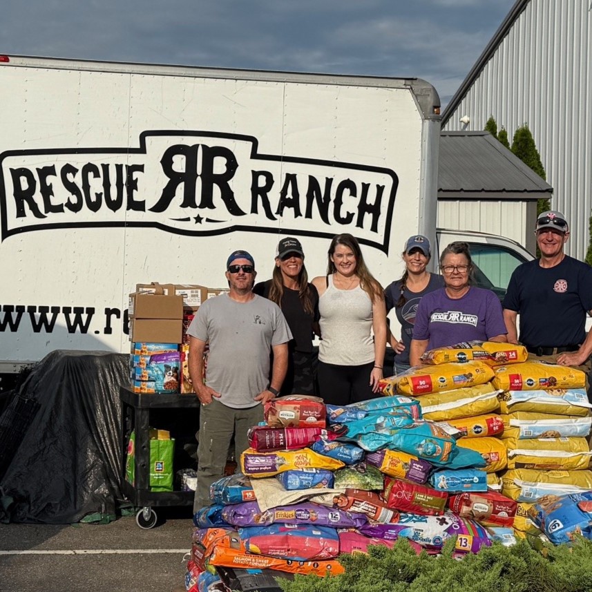 Rescue Ranch volunteers stand in front of donated supplies