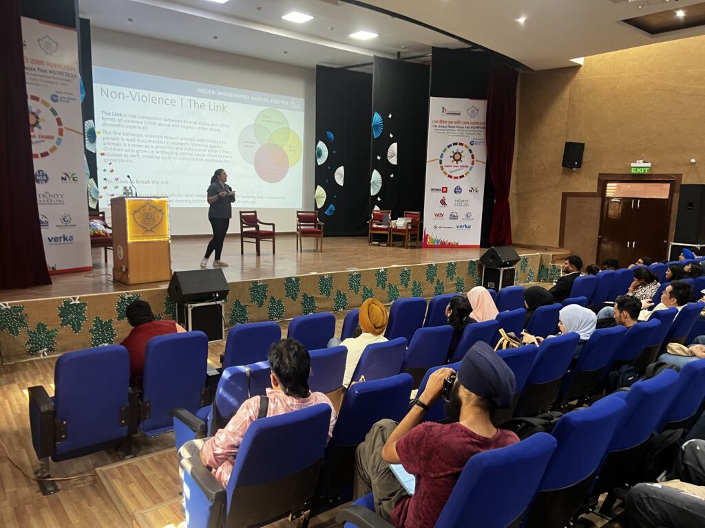 A woman in a blue shirt presenting to an auditorium