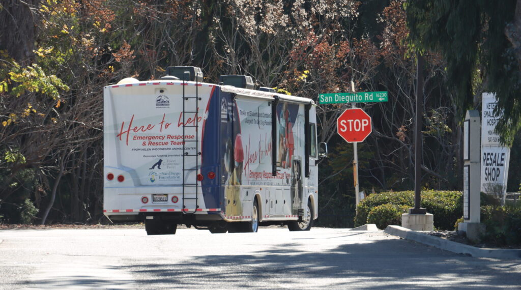 An RV with "Here to Help" on the side drives into the street.