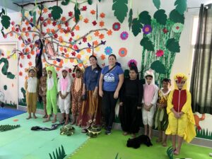 Two educators standing with several children dressed as animals