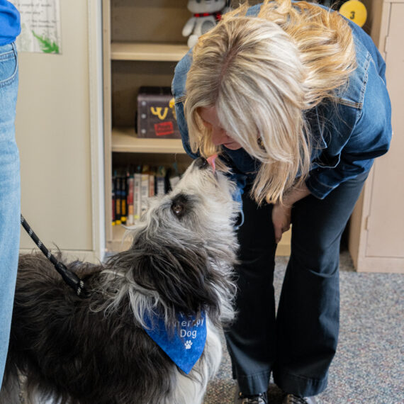 Woman bending over to look closely at a dog