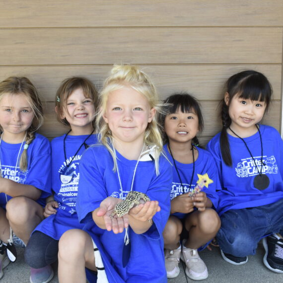 Children at camp with one holding a gecko