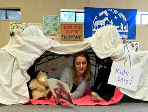 a person under a custom fort with a book