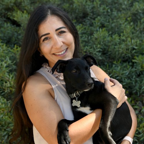 Dr. Hygan Baghoyan, Woman smiling with dark brown hair holding a black puppy.